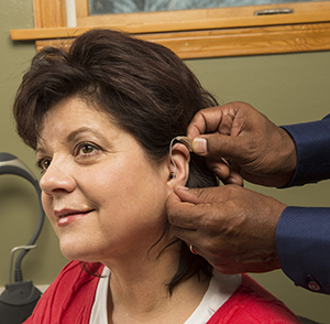 Woman being fitted with hearing aid.