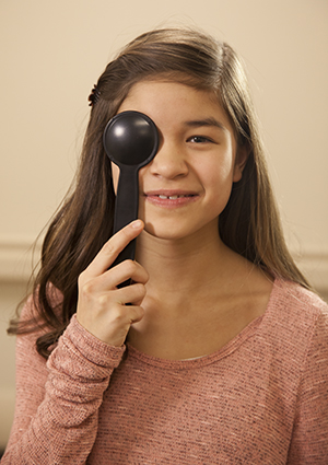 Girl holding a cover over her eye during an eye exam